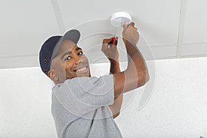 Electrician removing battery from smoke detector photo