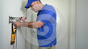 Electrician Removing a Toggle Switch from a Wall