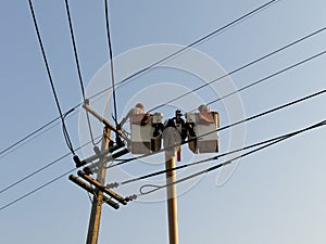 Electrician repairing cable on a power pole with electric repair service truck Internet phone back to normal