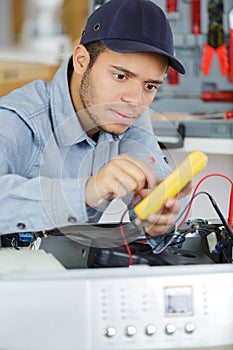 electrician repairing clothes washer with gripper