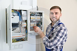 Electrician repairing fuse box with screwdriver