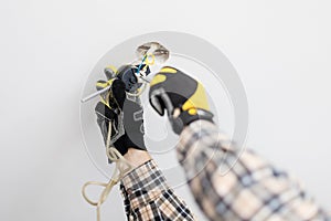 Electrician repairing suspend of ceiling lamp