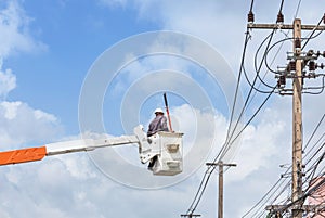 Electrician repairing wire of the power line with bucket hydraulic lifting platform