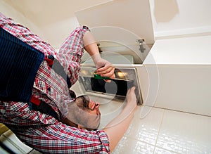 Repairman work on ventilation in the kitchen