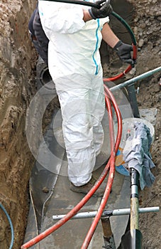 Electrician in road excavation during the repair job of a large