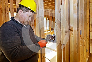 Electrician routing wires in electric plug connector electric sockets on the wall