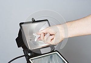 Electrician's hand changing a halogen
