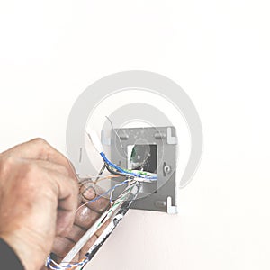 Electrician& x27;s hands when installing the socket