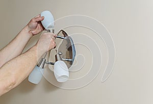 Electrician`s hands are instilling a wall lamp photo