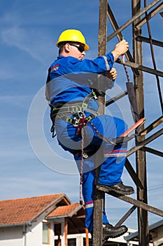 Electrician with safety belt climb on lamppost