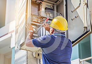 Electrician screwing equipment repairing in fuse circuit breaker box