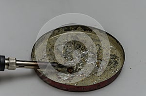 Electrician with a soldering iron melts flux rosin for soldering