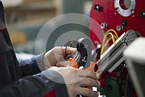 Electrician with stripper installing energy system on machinery industry