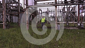 Electrician talking on phone and walking in electrical substation
