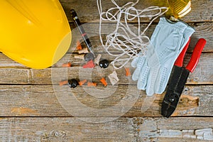 Electrician technician at work prepares the tools and cables used in electrical installation and yellow helmet