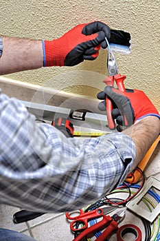 Electrician technician at work with safety equipment on a residential electrical system