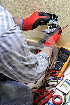 Electrician technician at work with safety equipment on a residential electrical system