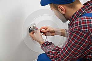 Electrician with tester checking voltage, closeup view