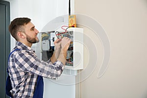 Electrician with tester checking voltage indoors