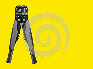 Electrician tool, wire stripper for cable stripping, network installing. Yellow background with copy photo
