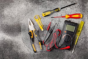 Electrician tools on black marble background.