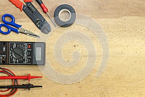 Electrician tools, components and instruments on a wooden background