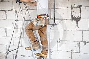 Electrician with tools, working on a construction site. Repair and handyman concept