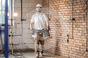 Electrician with tools, working on a construction site. Repair and handyman concept