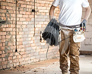 Electrician with tools, working on a construction site. Repair and handyman concept