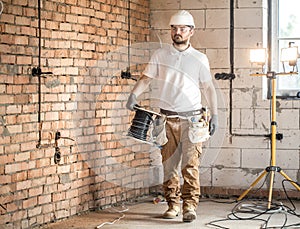 Electrician with tools, working on a construction site. Repair and handyman concept