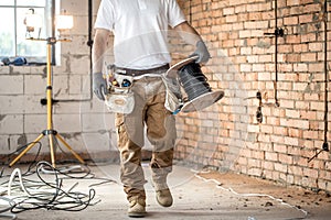 Electrician with tools, working on a construction site. Repair and handyman concept