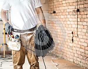 Electrician with tools, working on a construction site. Repair and handyman concept