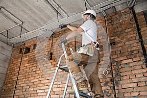 Electrician with tools, working on a construction site. Repair and handyman concept