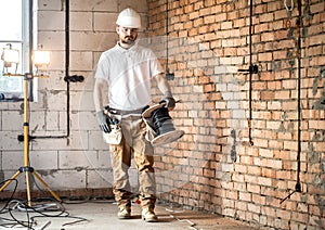 Electrician with tools, working on a construction site. Repair and handyman concept