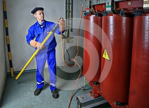 Electrician uses an insulating stick Earthing transformer. photo