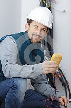 electrician using multimeter in renovation property photo