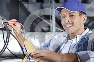 electrician using multimeter in roof space