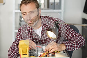 Electrician using multimeter to test computer
