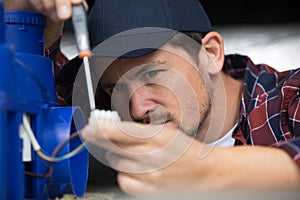 electrician using screwdriver on electrical junction box