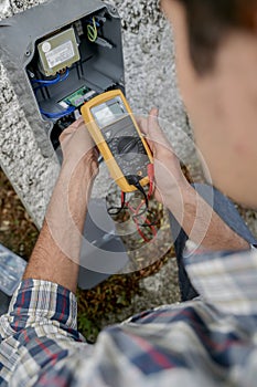 Electrician using voltmeter device