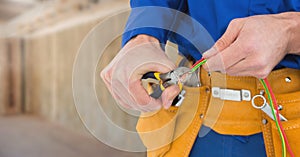 Electrician with wires cables on building site