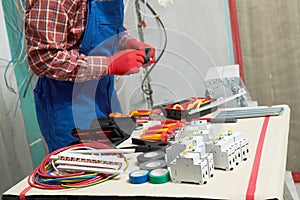 Electrician work with cable and circuit breaker. crimping pliers in use