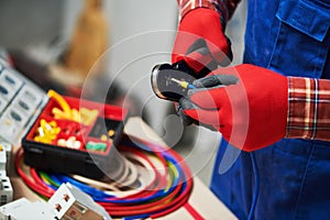 Electrician work with cable. crimping pliers in use