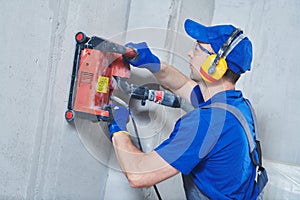 Electrician at work. cutting concrete wall for cabling by diamond slitting machine