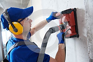 Electrician at work. cutting concrete wall for cabling by diamond slitting machine photo