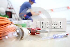 Electrician work with electrical equipment in the foreground, bulb, tools socket, electric circuits, electrical wiring