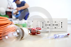 Electrician work with electrical equipment in the foreground, bulb, tools and socket, electric circuits, electrical wiring