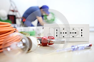 Electrician work with electrical equipment in the foreground  bulb, tools and socket, electric circuits, electrical wiring