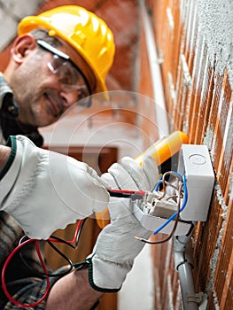 Electrician at work in an electrical system of a construction site. Construction industry