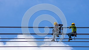 Electrician work installation of high voltage cable in high voltage safely and systematically over and blue sky background